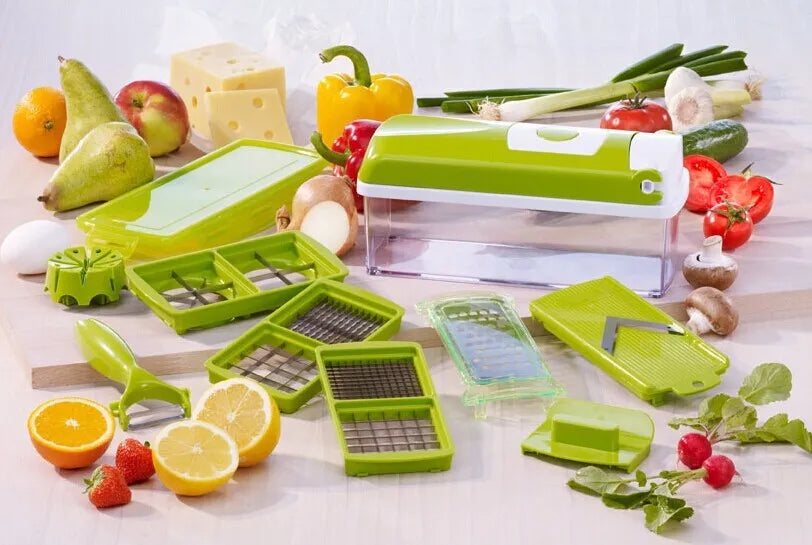 Green manual vegetable chopper with stainless steel blades and multiple cutting accessories on kitchen counter