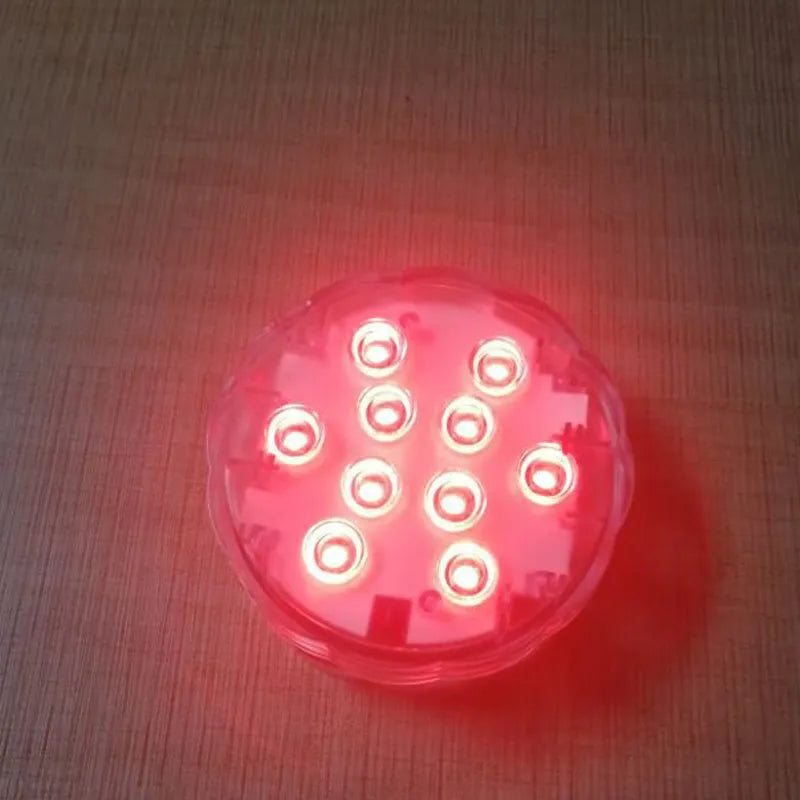 White waterproof LED disc light with remote control for pools and gardens.