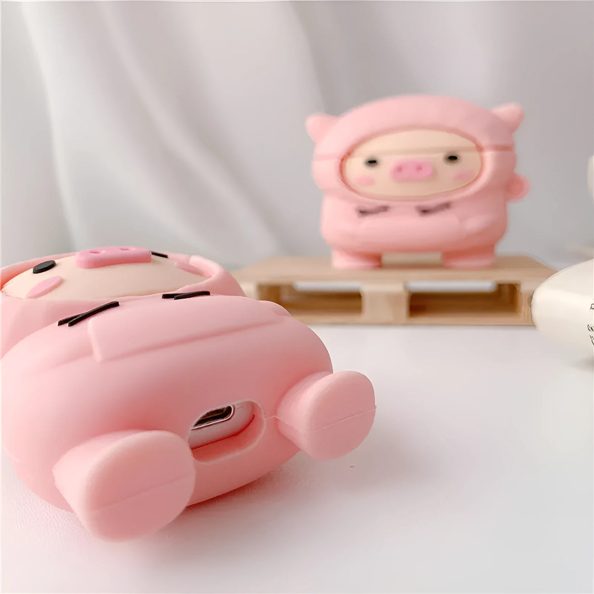 Pink cartoon pig design silicone flip case for Apple AirPods with an attached metal carrying hook.