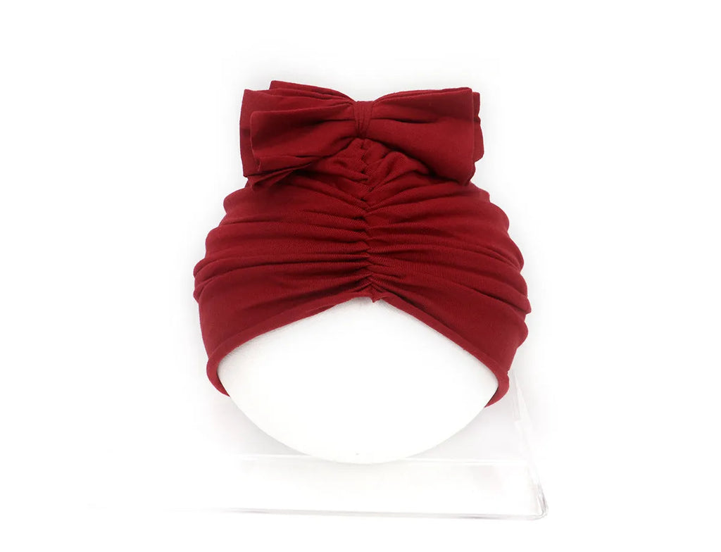 Soft acrylic knitted baby hat in a solid colour, shown on a mannequin head.