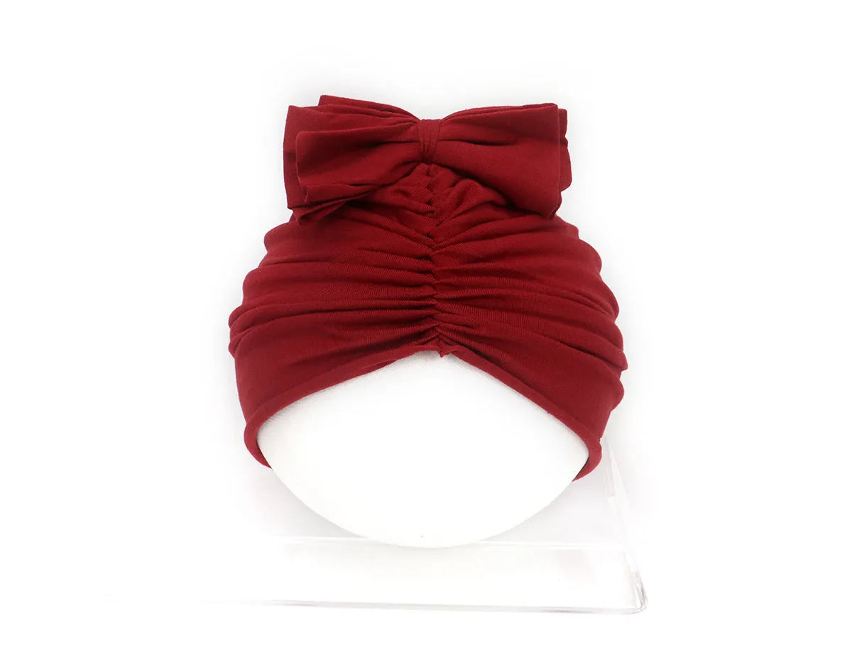 Soft acrylic knitted baby hat in a solid colour, shown on a mannequin head.
