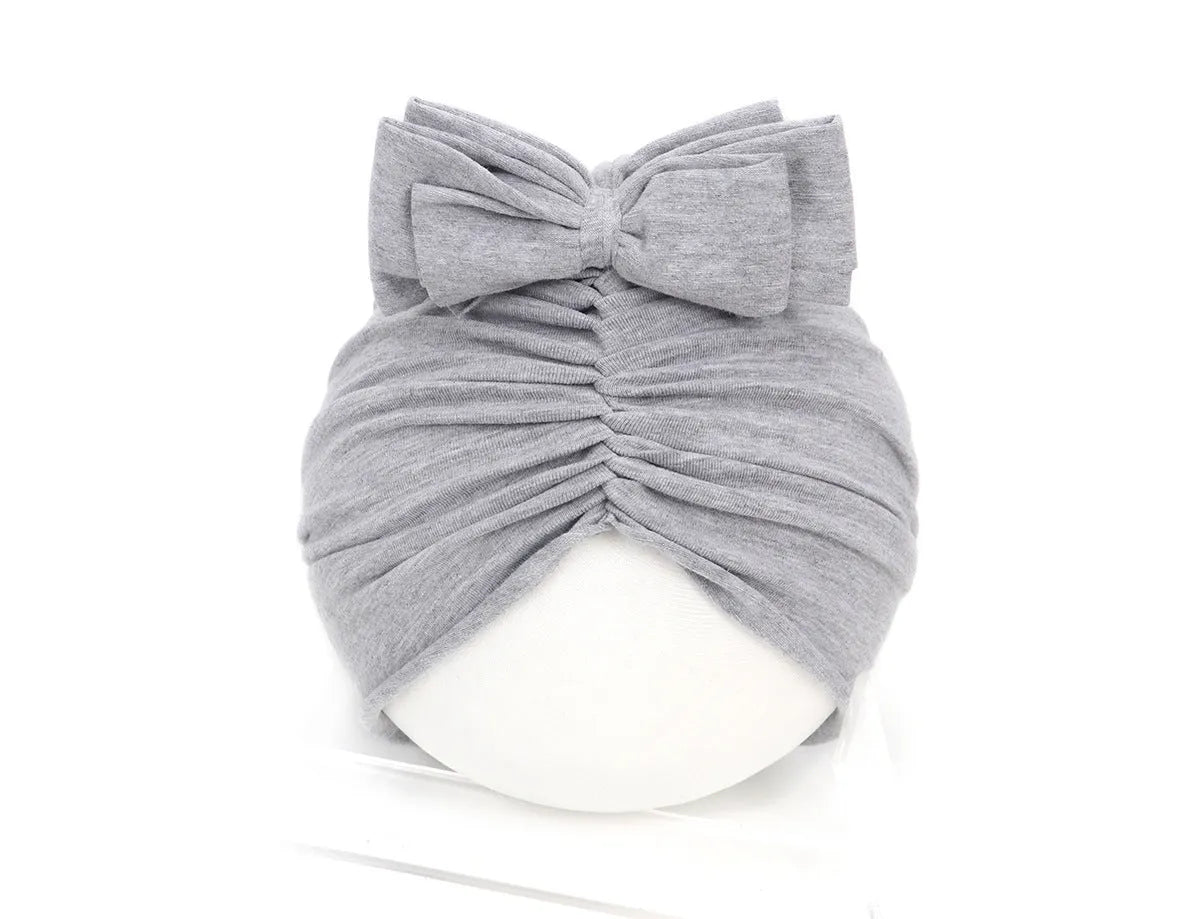 Soft acrylic knitted baby hat in a solid colour, shown on a mannequin head.