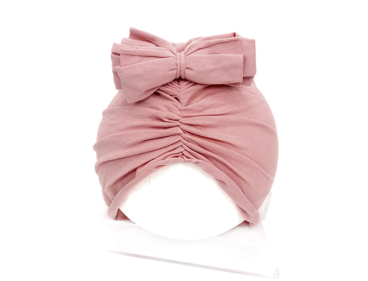 Soft acrylic knitted baby hat in a solid colour, shown on a mannequin head.