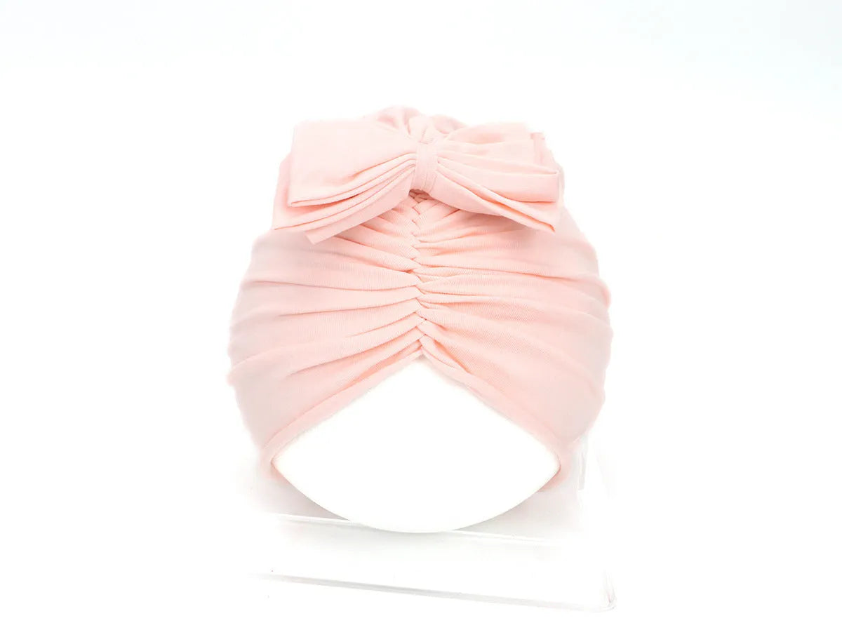Soft acrylic knitted baby hat in a solid colour, shown on a mannequin head.