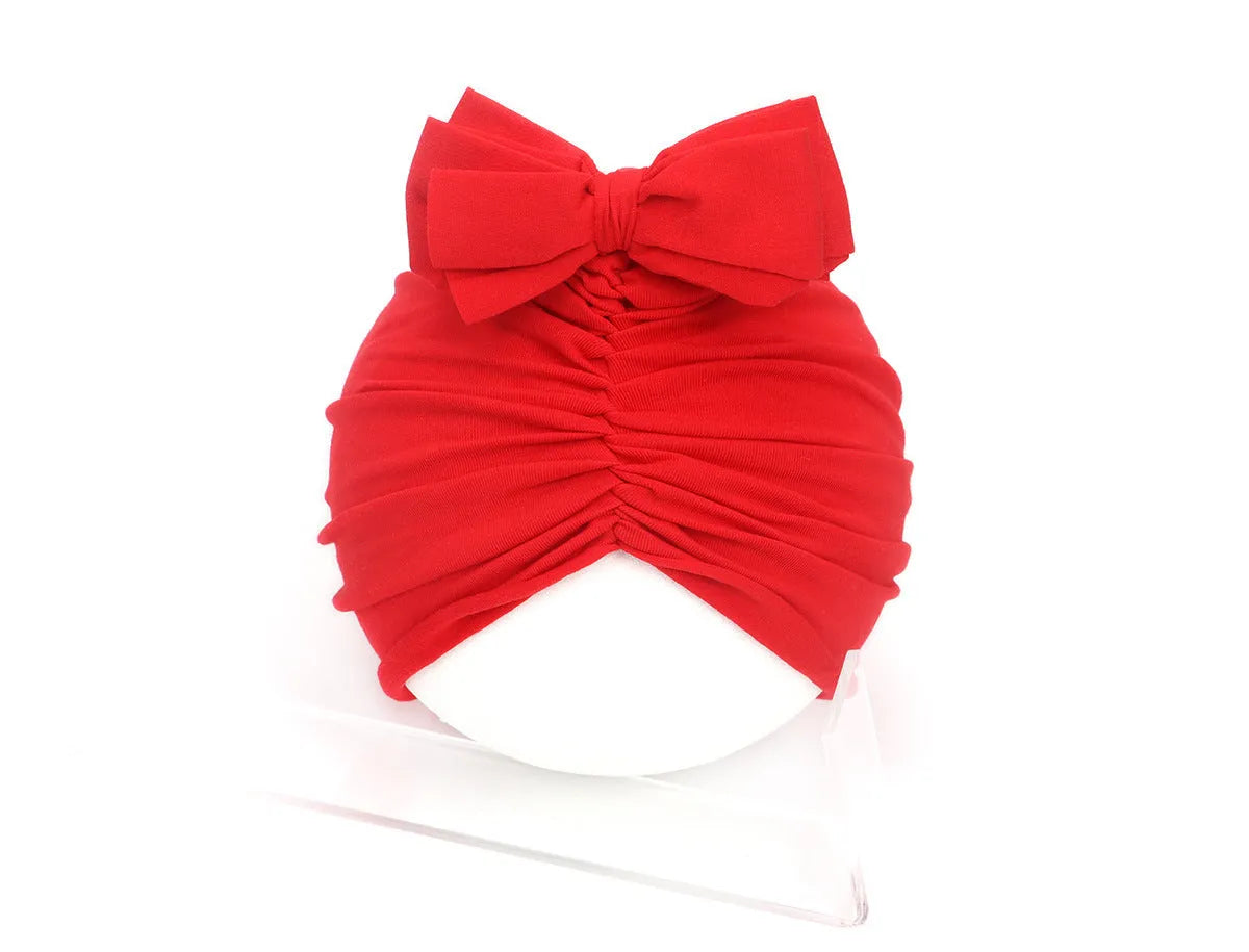 Soft acrylic knitted baby hat in a solid colour, shown on a mannequin head.