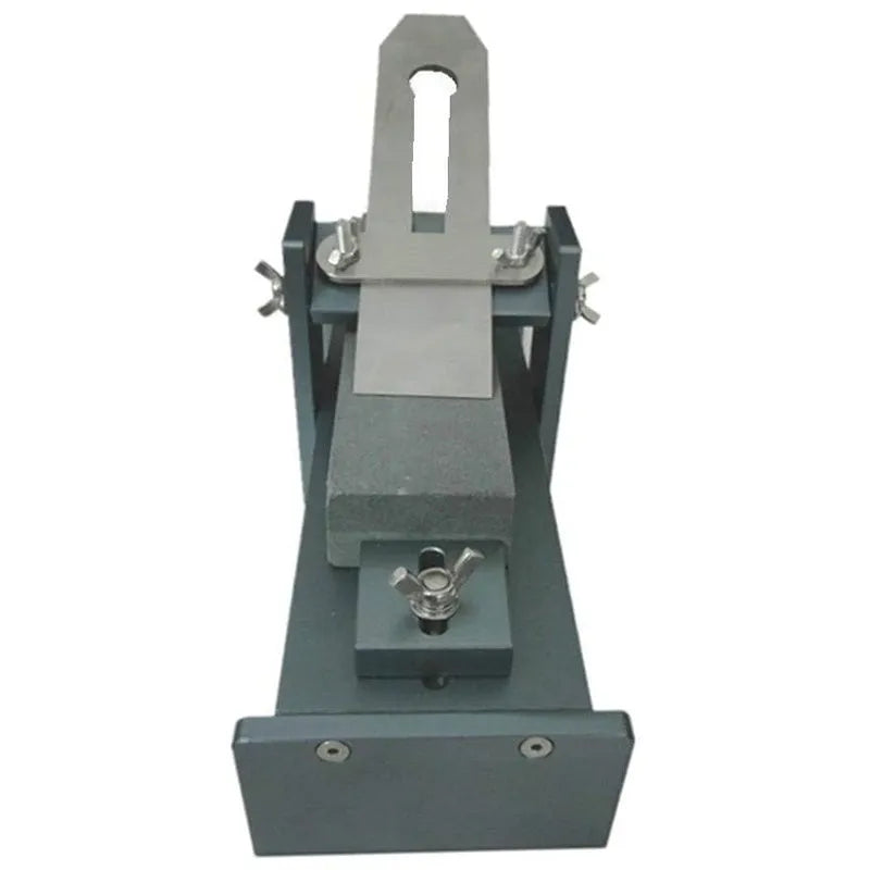 Aluminium alloy fixed angle sharpening tool for woodworking chisels and carving knives on a workbench.