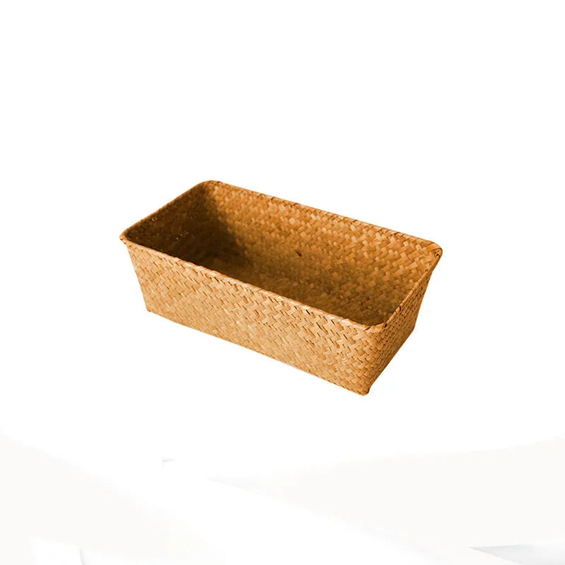 Woven straw desk storage box in natural brown colour, shown empty on a wooden surface