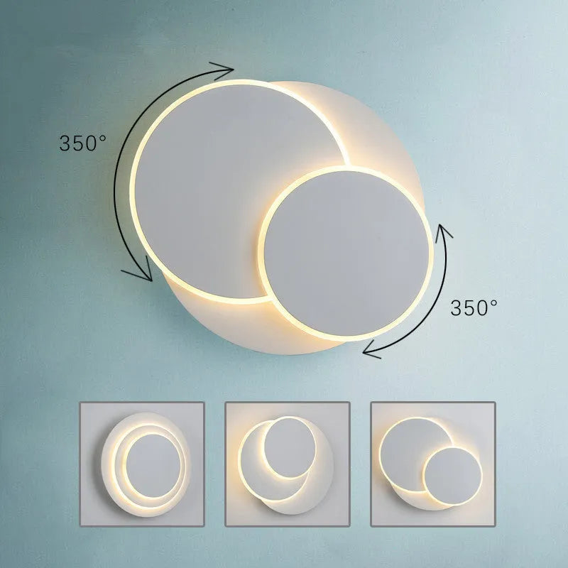 Modern round acrylic wall lamp in black or white on a bedroom wall.