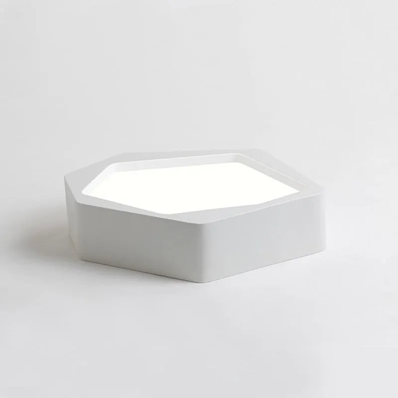 Geometric shaped iron LED light with remote control on a side table.