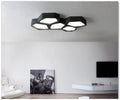 Geometric shaped iron LED light with remote control on a side table.