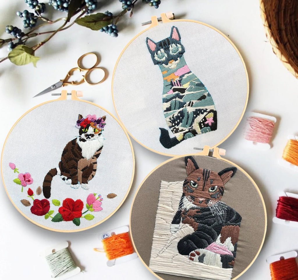 Beginners DIY cross stitch kit with cat design, embroidery threads, and fabric on a 15cm hoop.