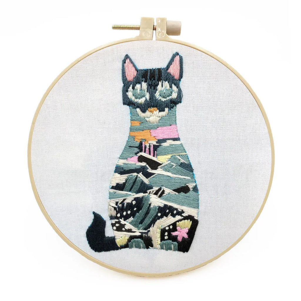 Beginners DIY cross stitch kit with cat design, embroidery threads, and fabric on a 15cm hoop.
