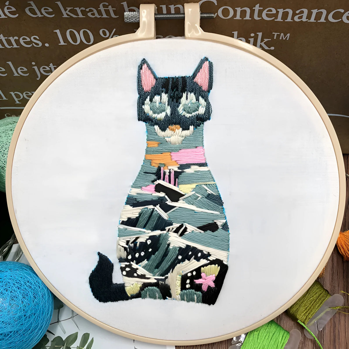 Beginners DIY cross stitch kit with cat design, embroidery threads, and fabric on a 15cm hoop.