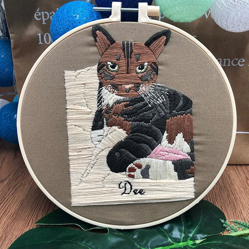 Beginners DIY cross stitch kit with cat design, embroidery threads, and fabric on a 15cm hoop.