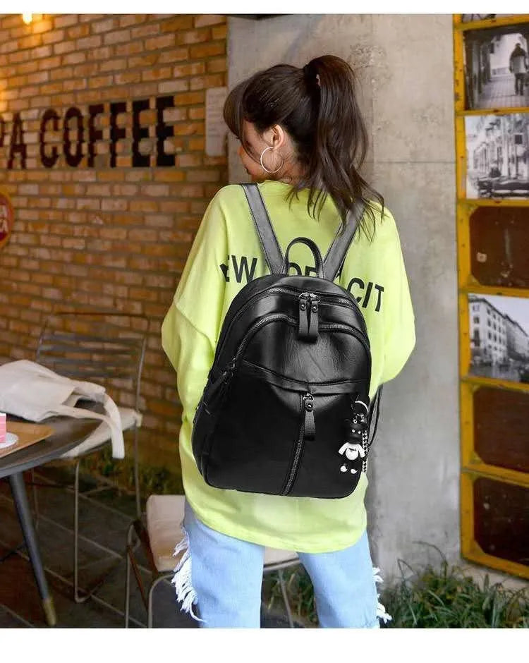 Black soft surface PU leather backpack showing double luggage straps and plain design.