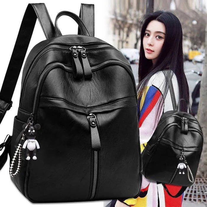 Black soft surface PU leather backpack showing double luggage straps and plain design.