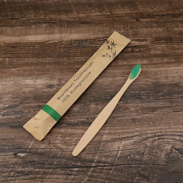 Ten bamboo toothbrushes with coloured handles and charcoal bristles laid out side by side.