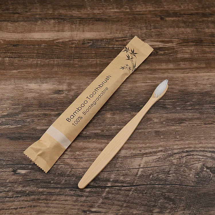 Ten bamboo toothbrushes with coloured handles and charcoal bristles laid out side by side.