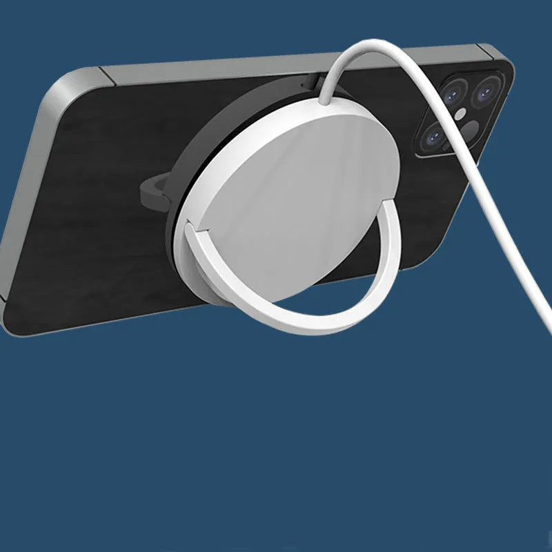 Black magnetic wireless charging car phone mount on a dashboard with a mobile phone attached.
