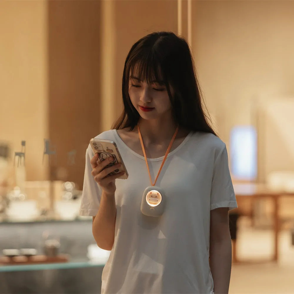 White hanging neck USB fan with 3 speed buttons shown in hand and around neck.