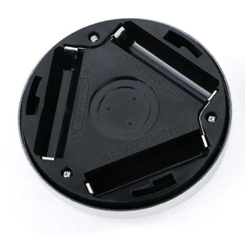 Silver-coloured circular wireless motion sensor night light on a surface