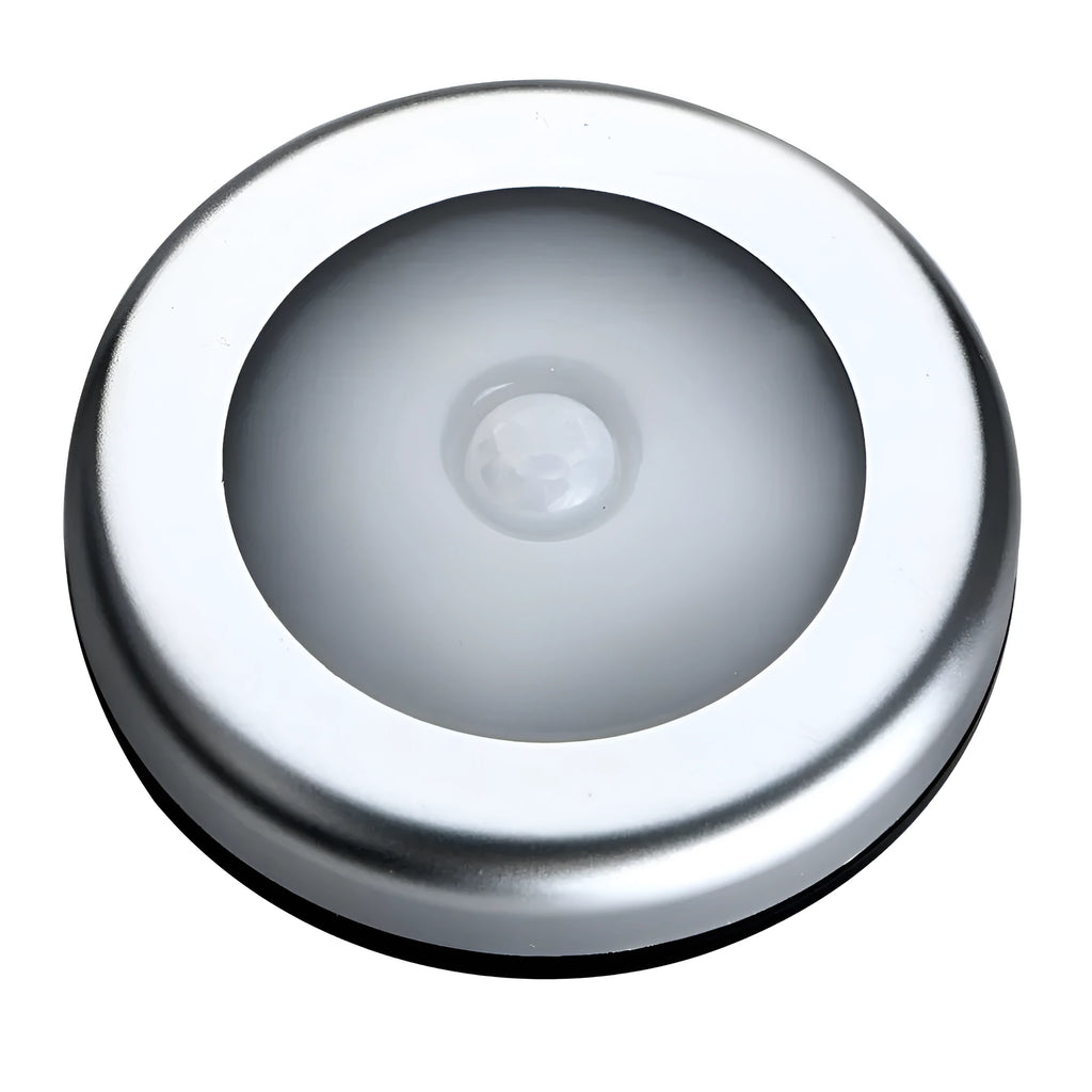 Silver-coloured circular wireless motion sensor night light on a surface