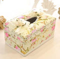 Ceramic jewellery and tissue storage box in bright apricot, holding rings and a tissue pack.