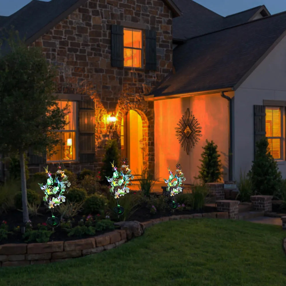 Solar cherry tree garden decoration light with ground insert spike on a lawn.