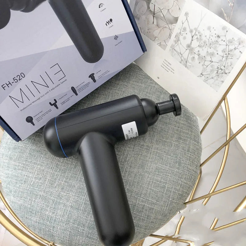 Black handheld muscle massage gun with percussion head showing USB charging port