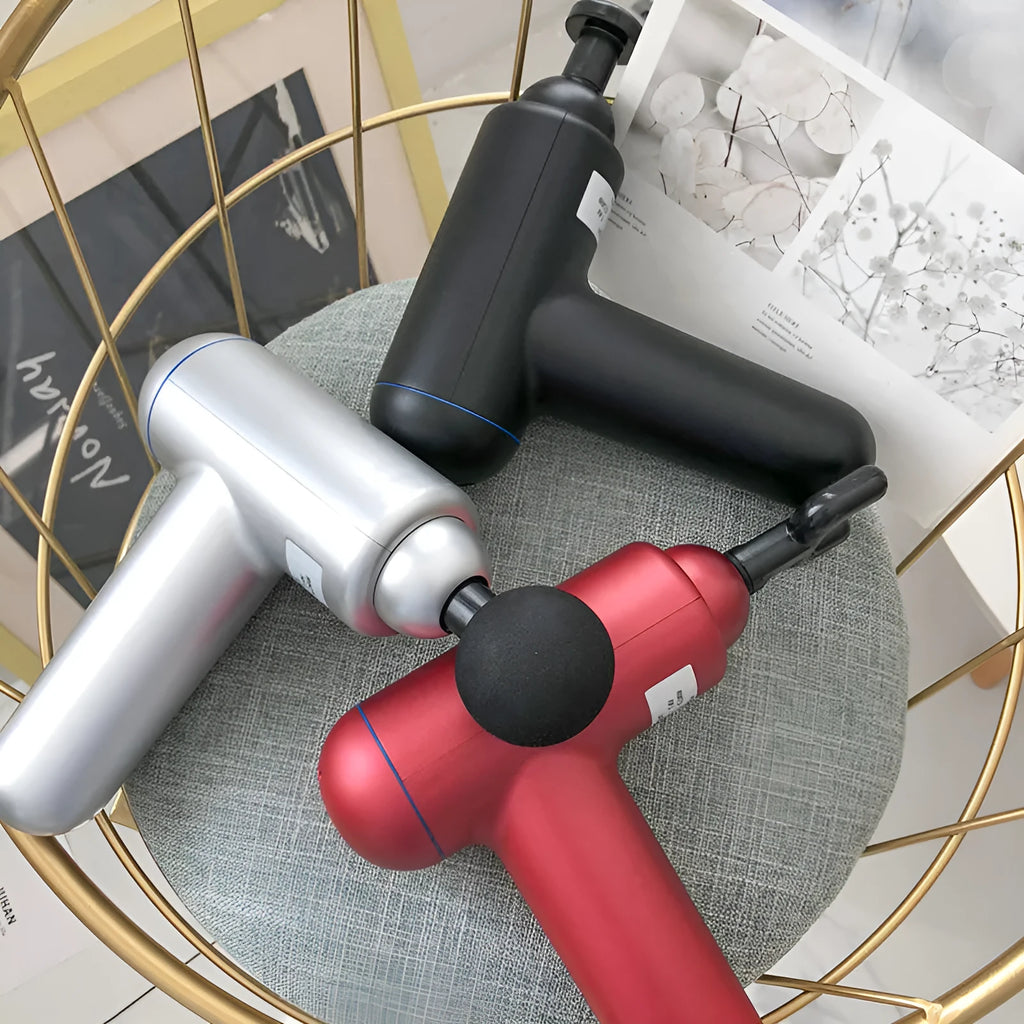 Black handheld muscle massage gun with percussion head showing USB charging port