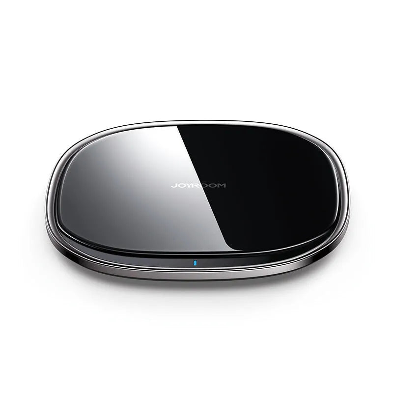 Slim black 15W Qi wireless charger with a zinc alloy frame and glass top on a wooden desk.