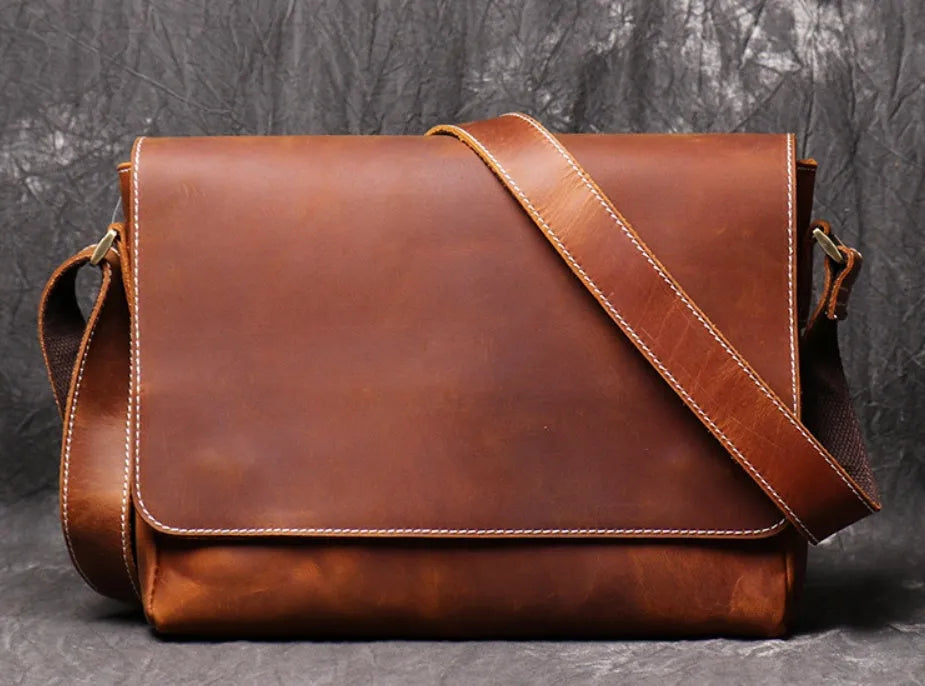 Vintage brown leather mens messenger bag with a flap opening and adjustable shoulder strap.