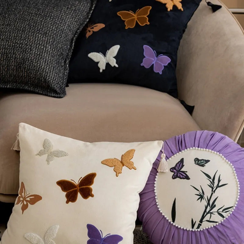 Square beige cushion with black butterfly embroidery in a Chinese style, 45cm by 45cm.