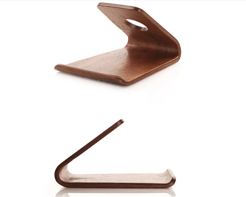 Wooden phone charging stand for iPhone in walnut or white maple finish on a desk.