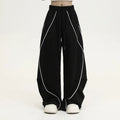 Black and white striped wide-leg hip hop trousers with front pleats on a mid-waist.