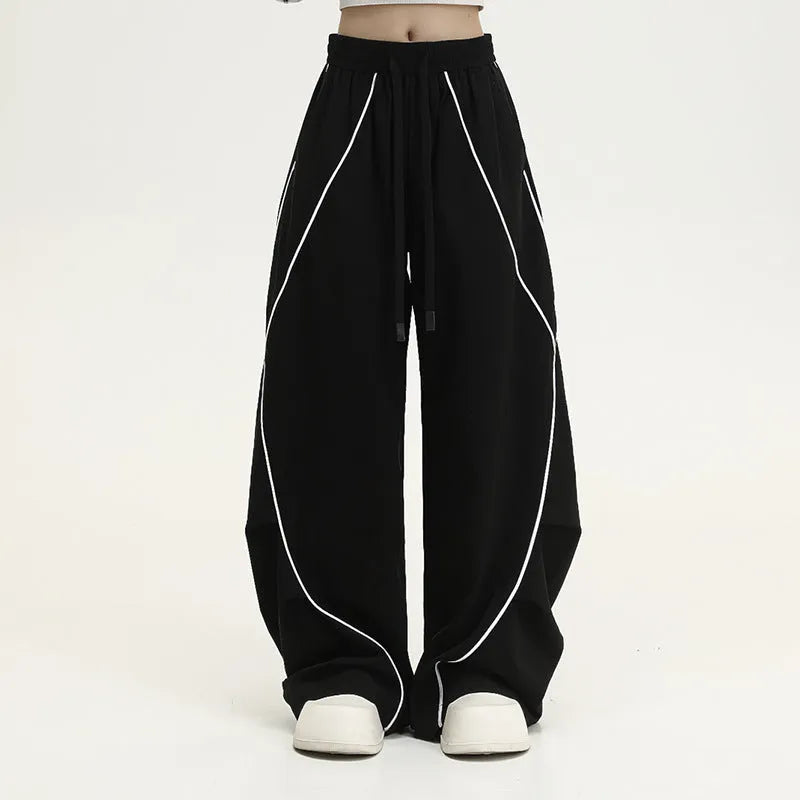 Black and white striped wide-leg hip hop trousers with front pleats on a mid-waist.