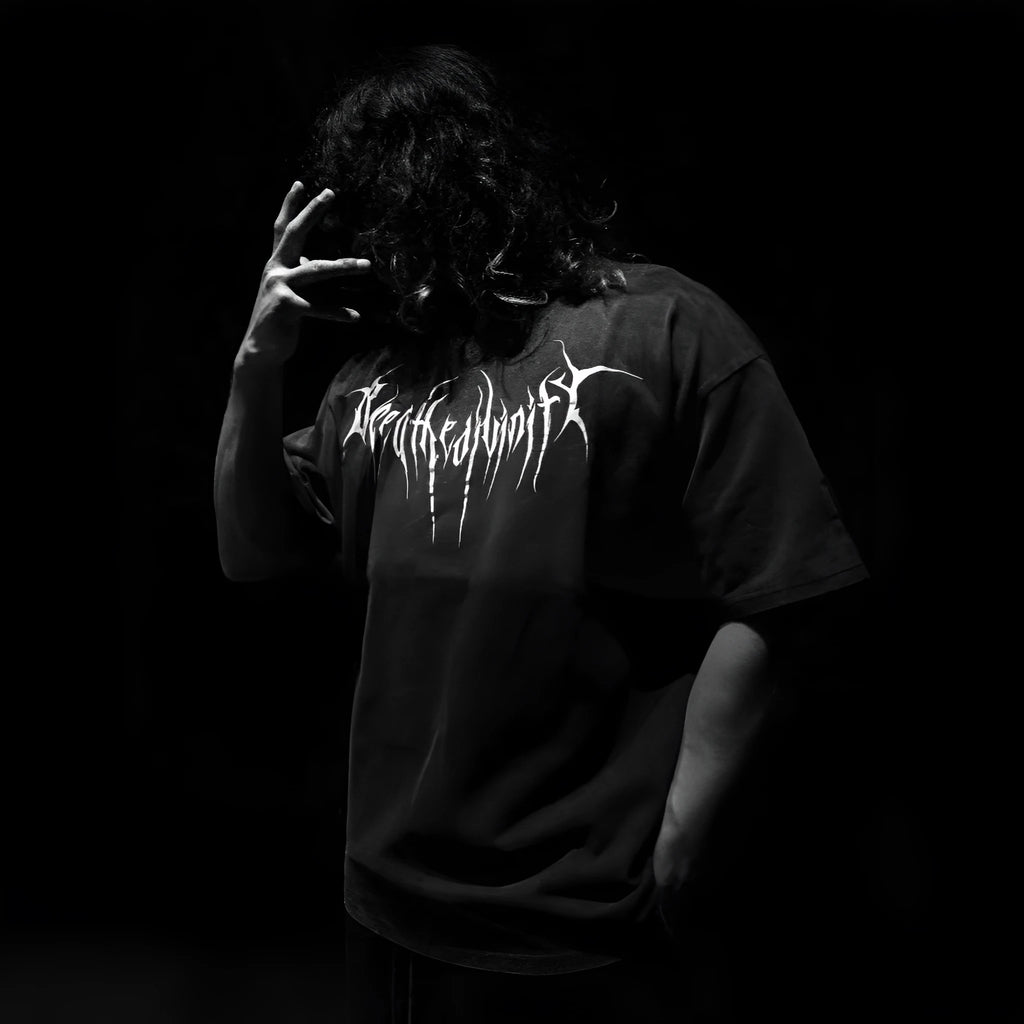 Man wearing a dark loose-fit cotton short-sleeved T-shirt with gilding detail