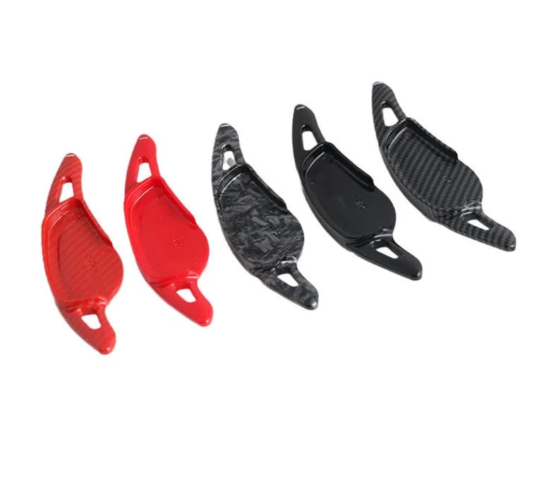Steering wheel paddle shifter for car interior in various finishes including carbon fibre.
