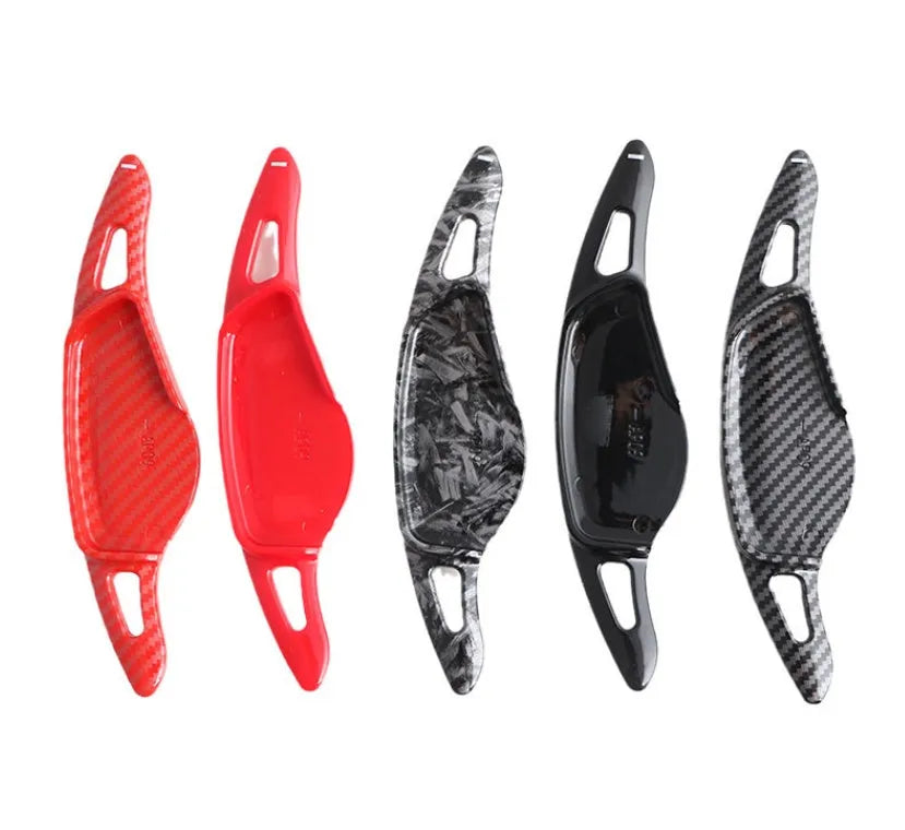 Steering wheel paddle shifter for car interior in various finishes including carbon fibre.