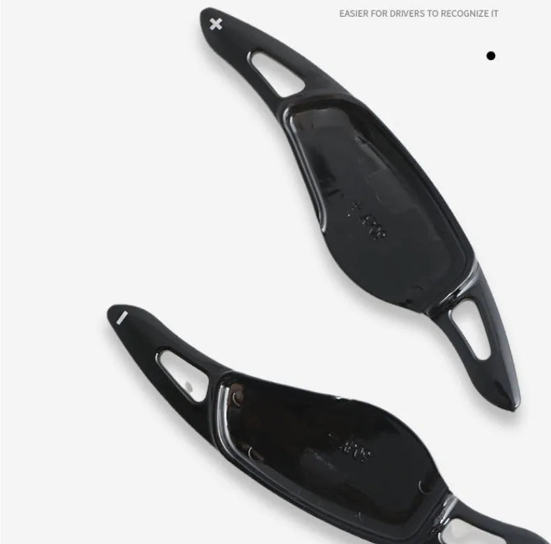 Steering wheel paddle shifter for car interior in various finishes including carbon fibre.