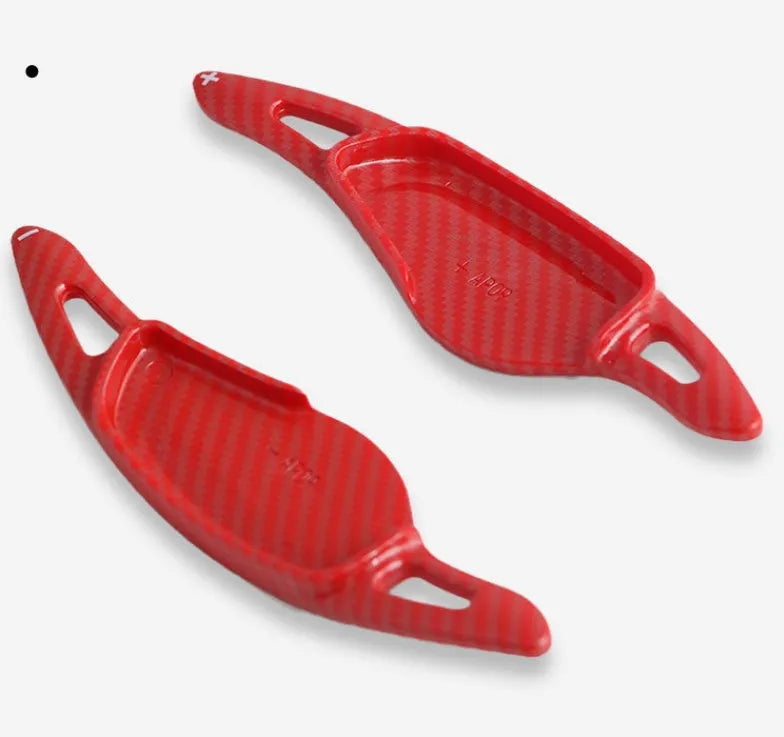 Steering wheel paddle shifter for car interior in various finishes including carbon fibre.