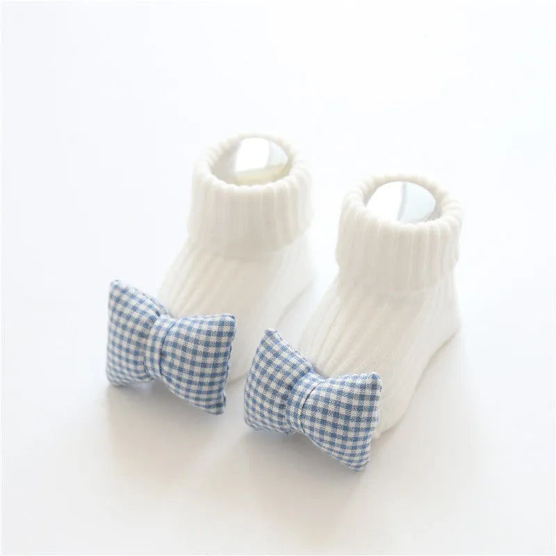 Cotton baby floor socks in a selection of colours and patterns like panda, lion, and bows, shown in sizes for infants.