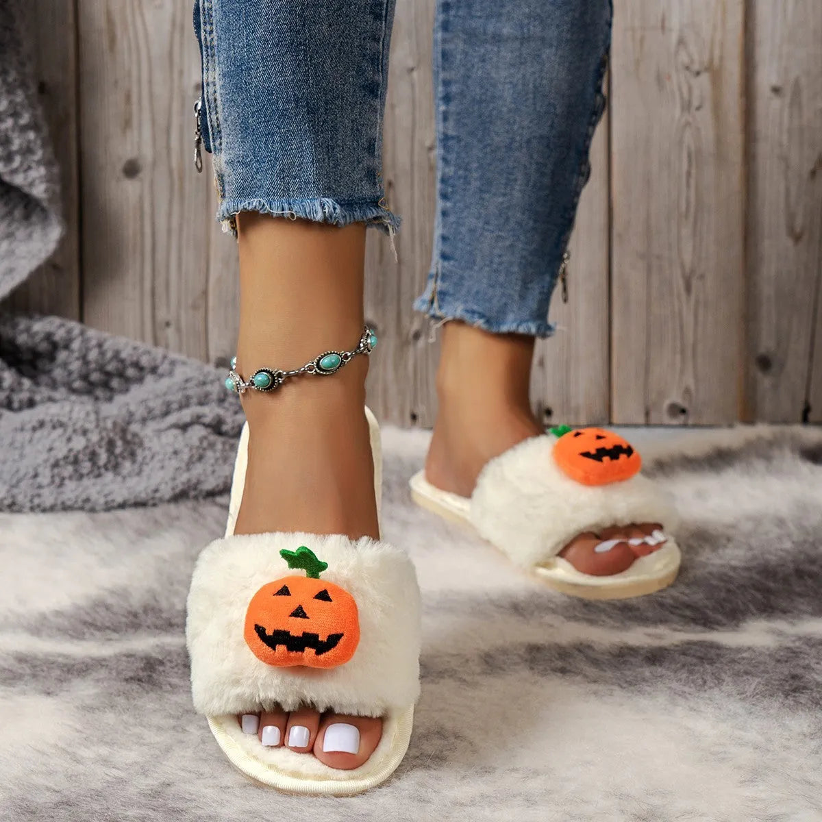 White and yellow pumpkin plush open toe slippers with cartoon Halloween design on synthetic fur