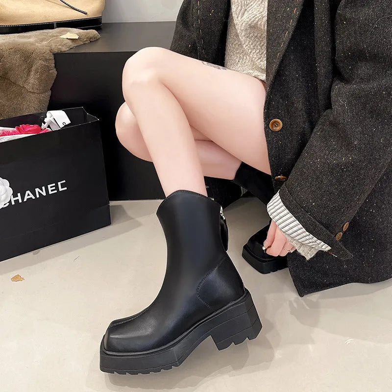 Women's black platform Martin boots with square toe, chunky sole, back zipper, and block heel.