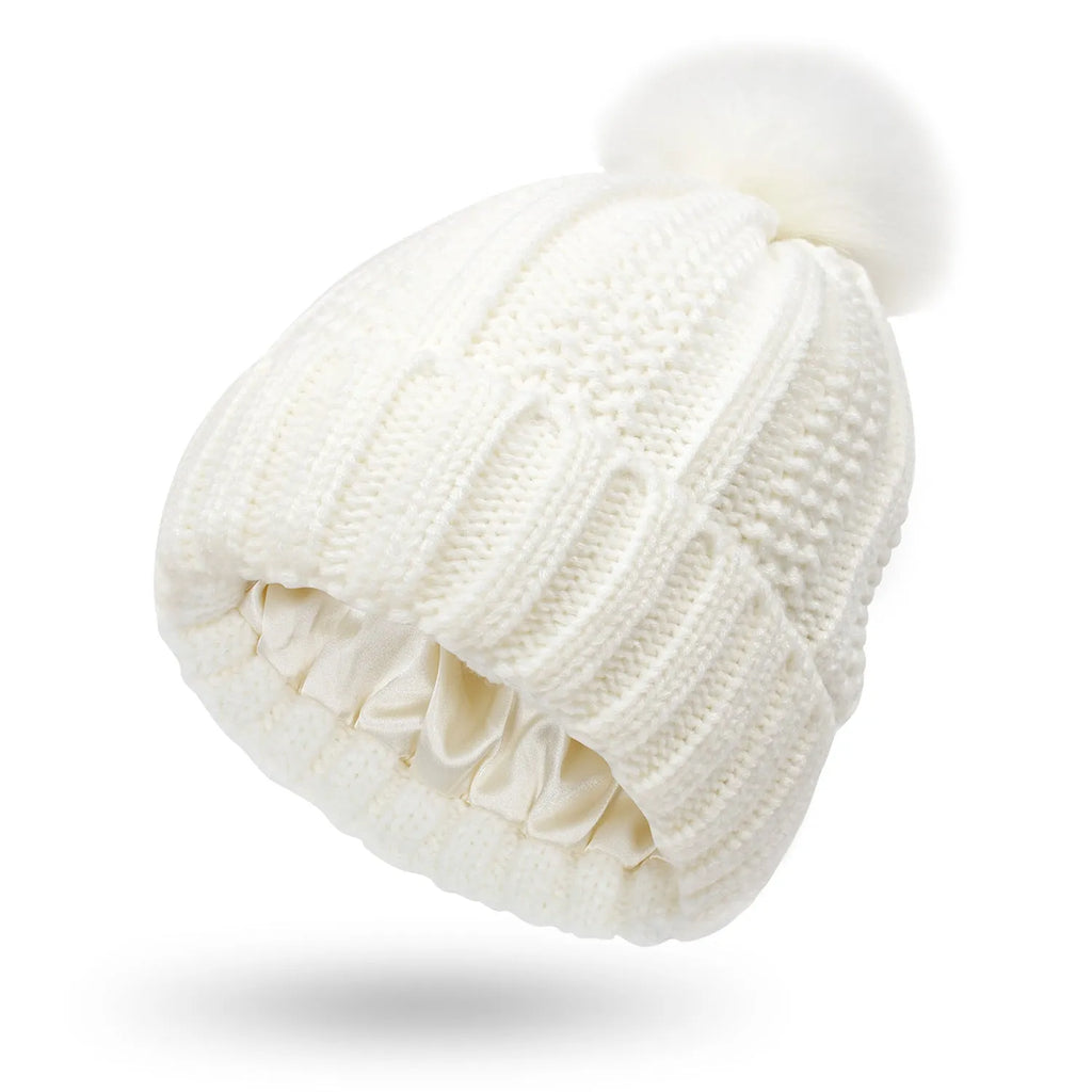 Wool beanie hat with faux fur pom pom, shown in black, with a visible satin lining.