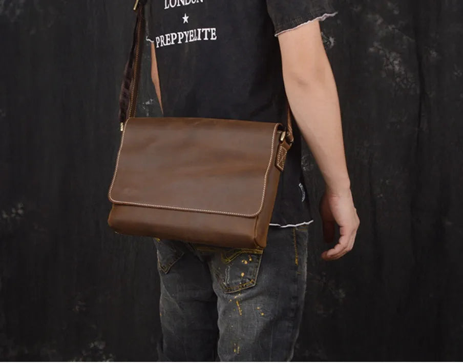 Vintage brown leather mens messenger bag with a flap opening and adjustable shoulder strap.