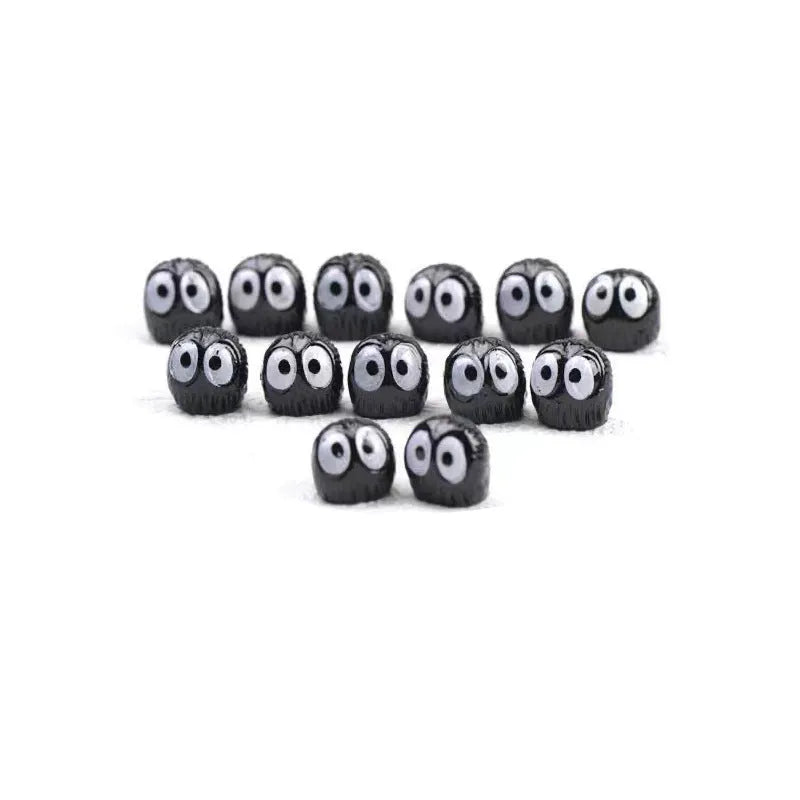 Small black resin coal ball cartoon decoration on a car dashboard.