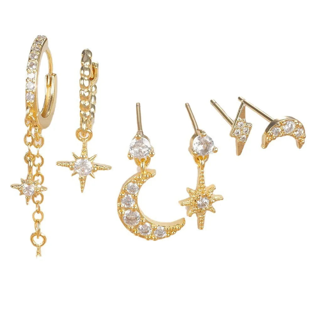 Set of six gold chain tassel drop earrings with crystal studs on a white background.