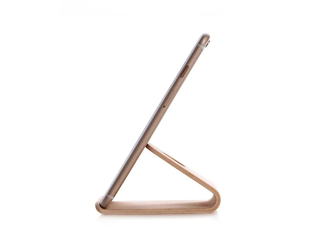 Wooden phone charging stand for iPhone in walnut or white maple finish on a desk.