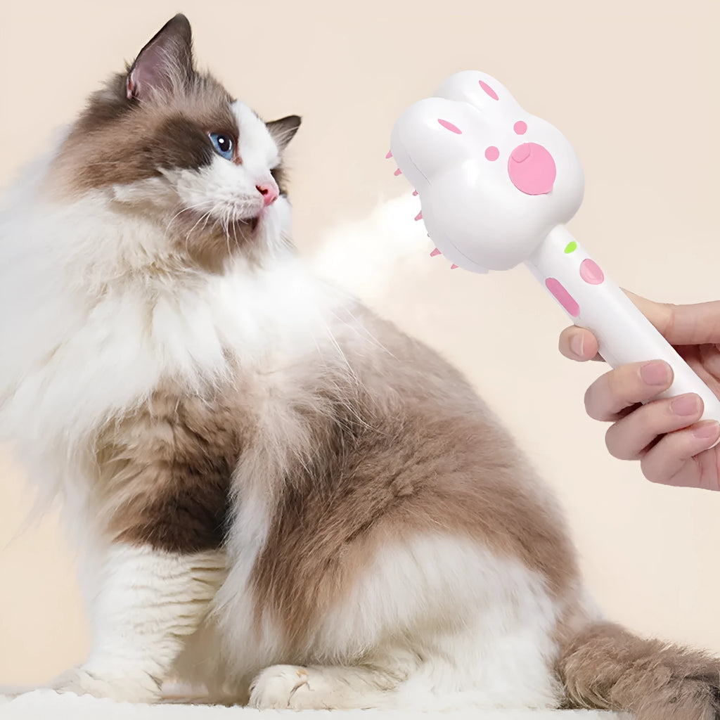Rechargeable pink cartoon-design steam brush comb for grooming cats and dogs on a table.